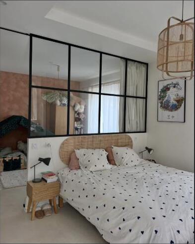 Verrière à petits carreaux séparant une chambre parentale et une chambre d'enfant.